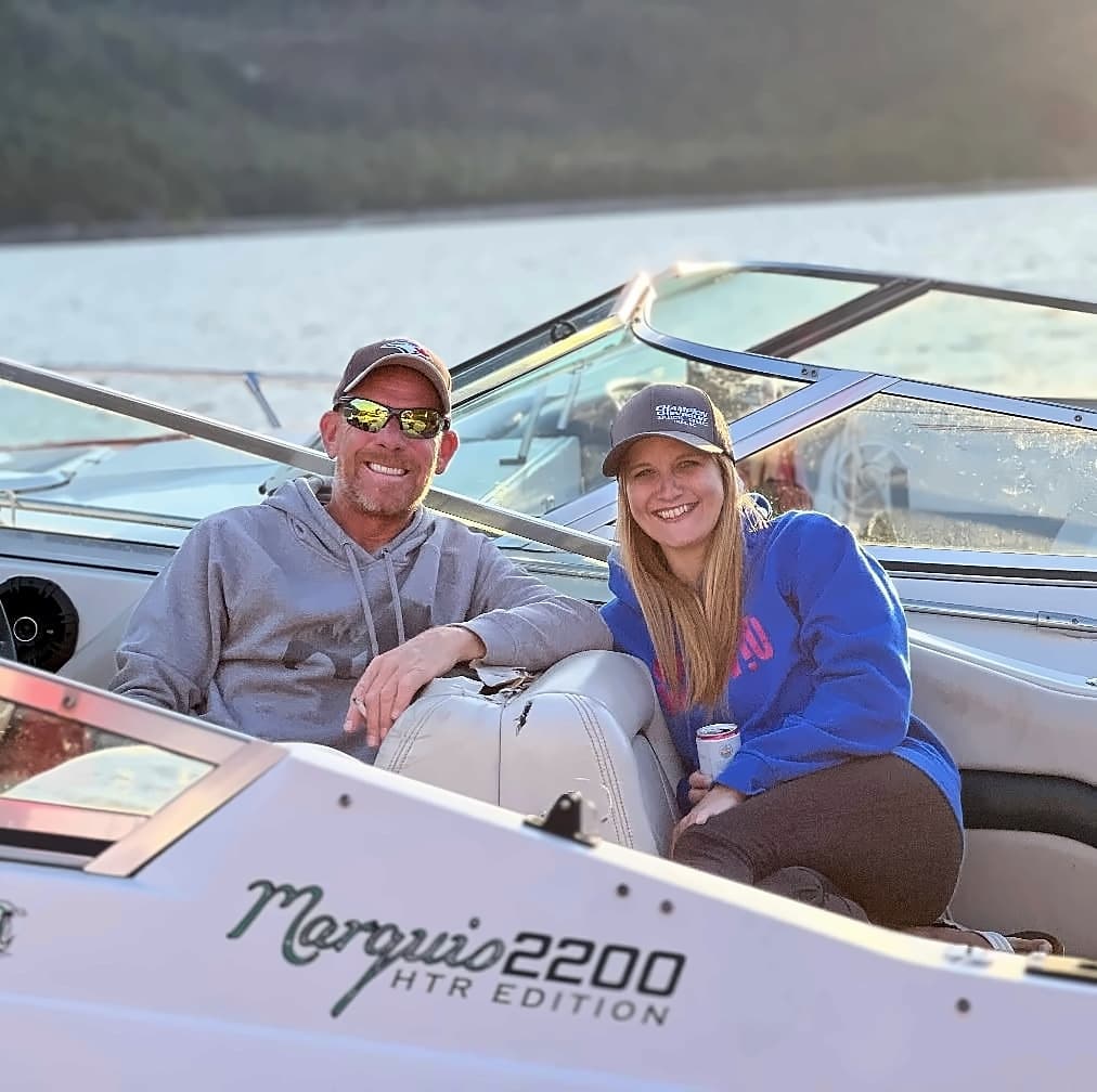 Dave and Tasha sitting together in a boat on the lake, both smiling.